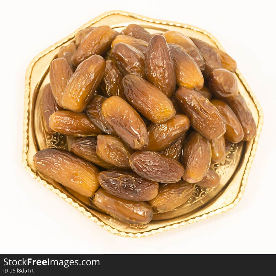 Dried figs on a polished bronze Iranian saucer isolated on white background