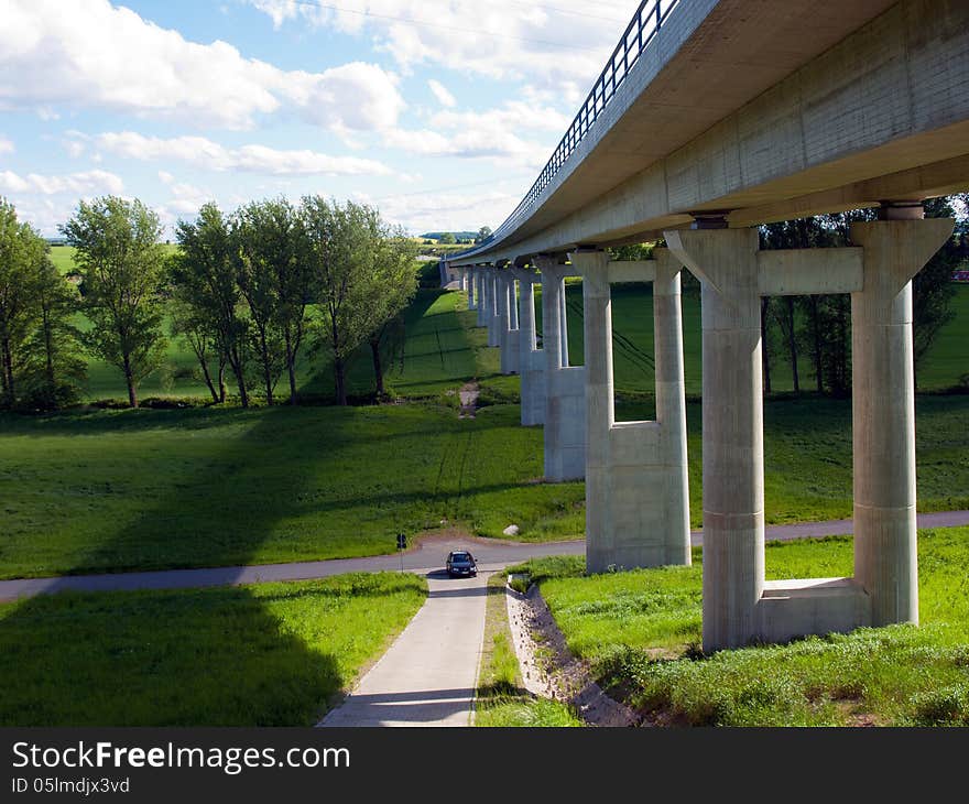 Modern bridge with green fields and blue sky