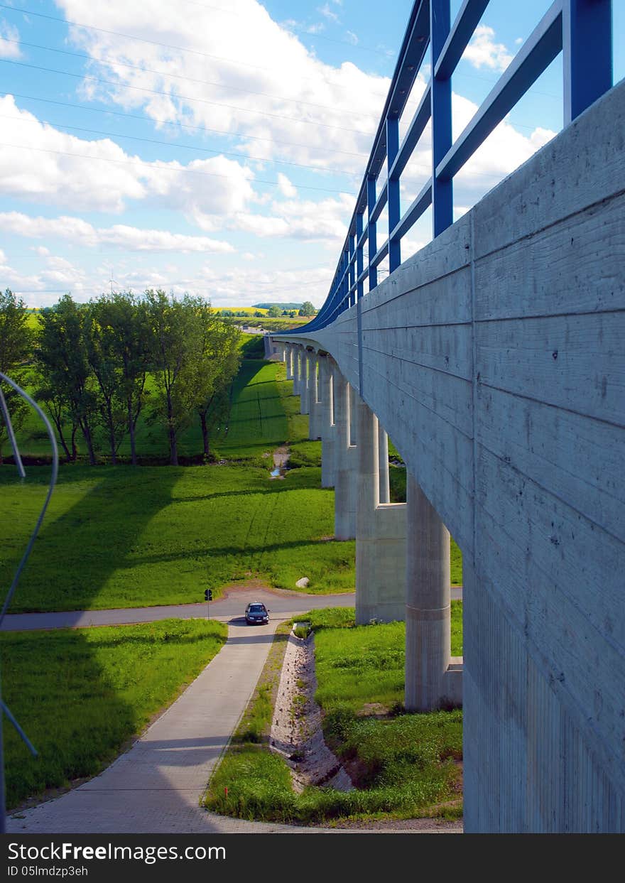 Modern bridge with green fields and blue sky