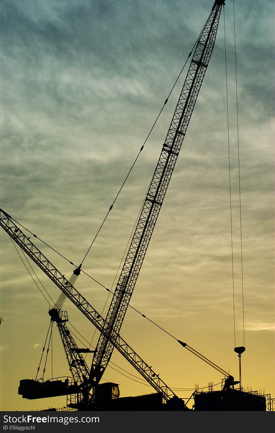 Silhouette of the tower crane on the construction site