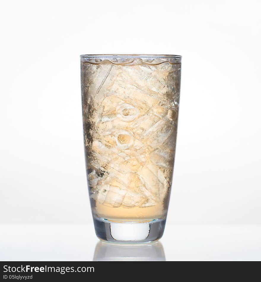 Sweet apple juice with ice in glass on white background