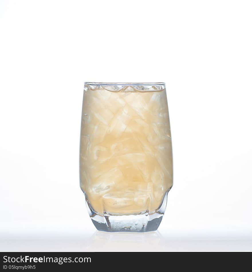 Cold ginger tea a Thai herbal drinks with ice in glass on white background