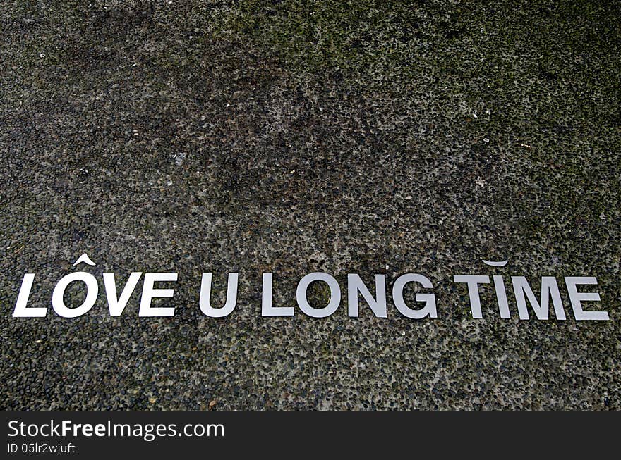 A Love you long time saying on a pavement.