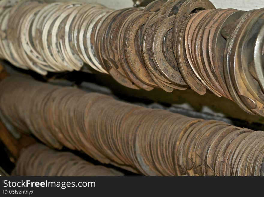 Three rows of various sizes of horseshoes hanging in the back of a farrier's trailer. Three rows of various sizes of horseshoes hanging in the back of a farrier's trailer.