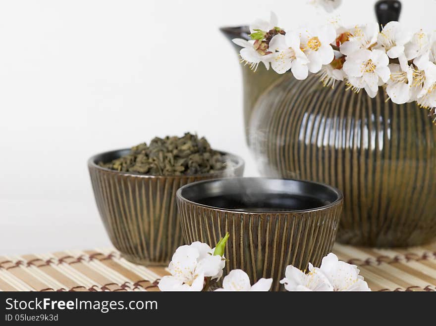 Teapot, cups and blooming cherry twig. Teapot, cups and blooming cherry twig