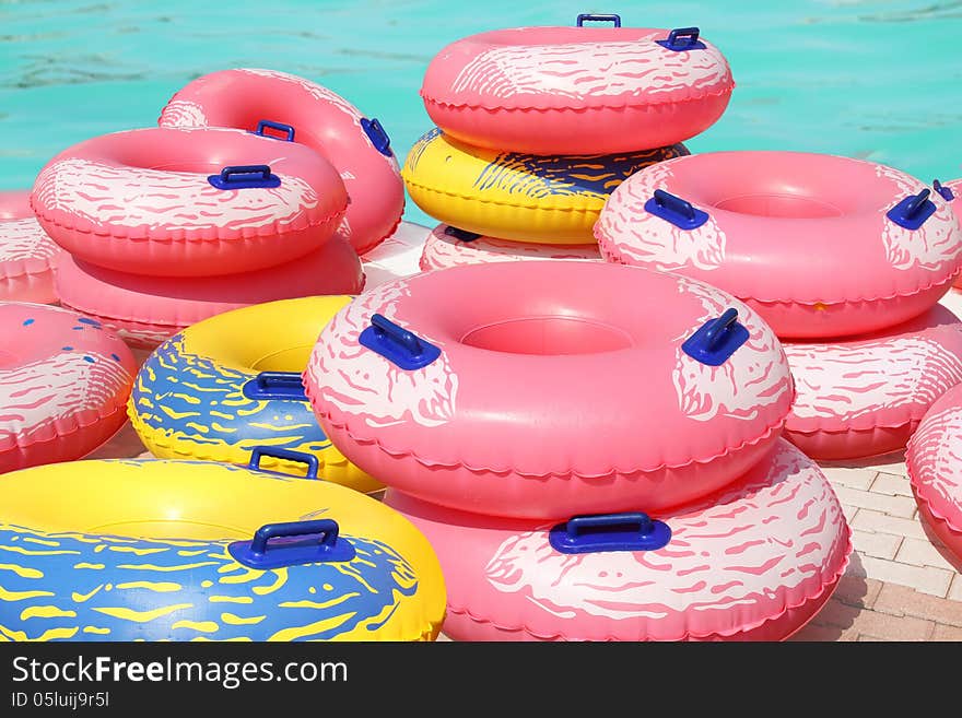 A lot of colorful inflatable swim rings by the swimming pool