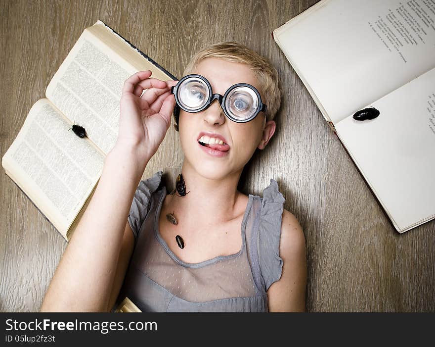 Portrait of crazy student in glasses with books and cockroaches