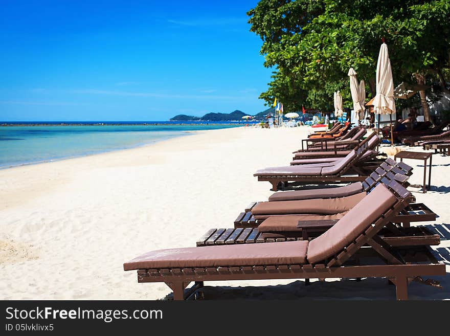 Wooden deck chairs on the sandy beach.