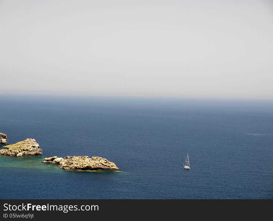 A sailing ship passes by in Lindos Bay, Lindos, Greece. A sailing ship passes by in Lindos Bay, Lindos, Greece