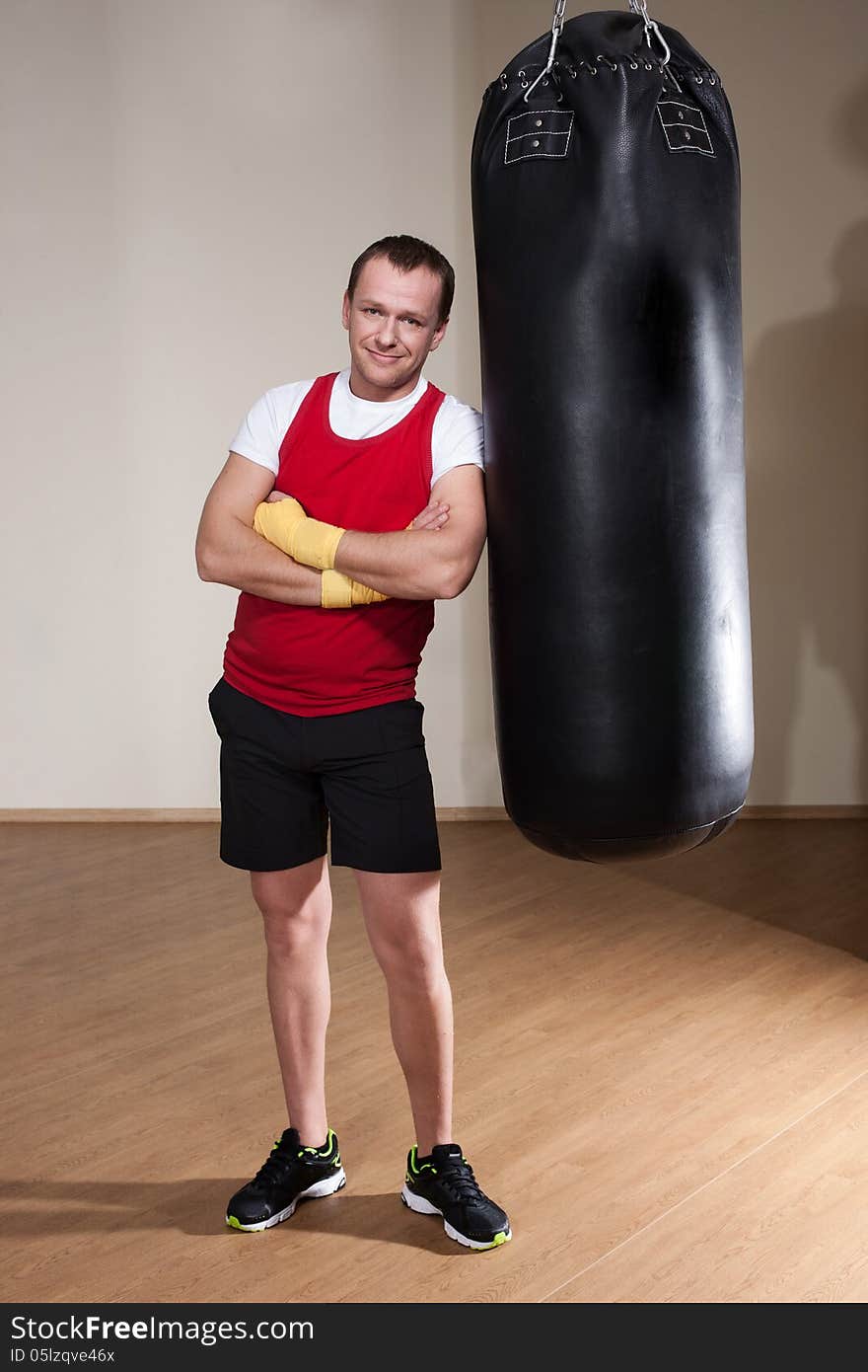 Man in boxing gloves makes a series of exercises punching bag. Man in boxing gloves makes a series of exercises punching bag