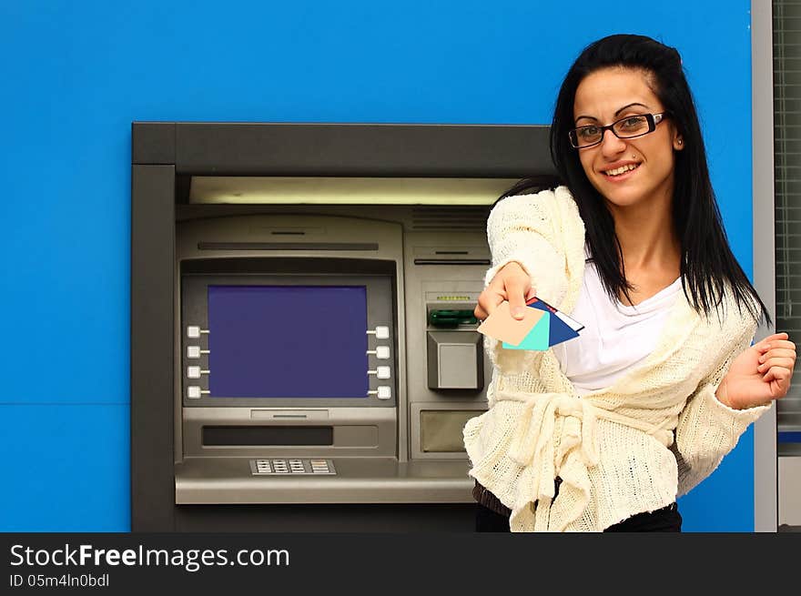 Woman in-front of atm machine offering credit cards. Woman in-front of atm machine offering credit cards