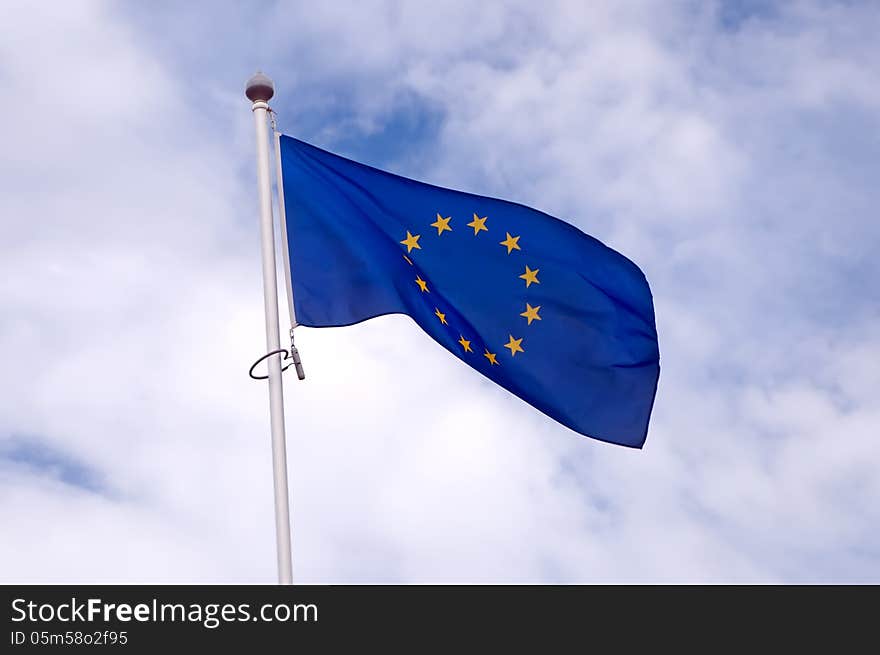 EU flag swaying in the background of the cloudy sky