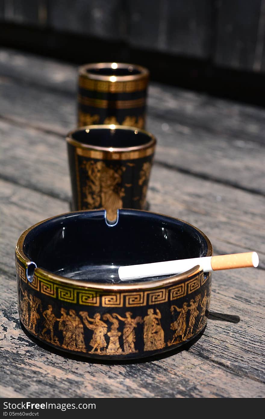 Cigarette in ashtray with Greek motifs. Cigarette in ashtray with Greek motifs