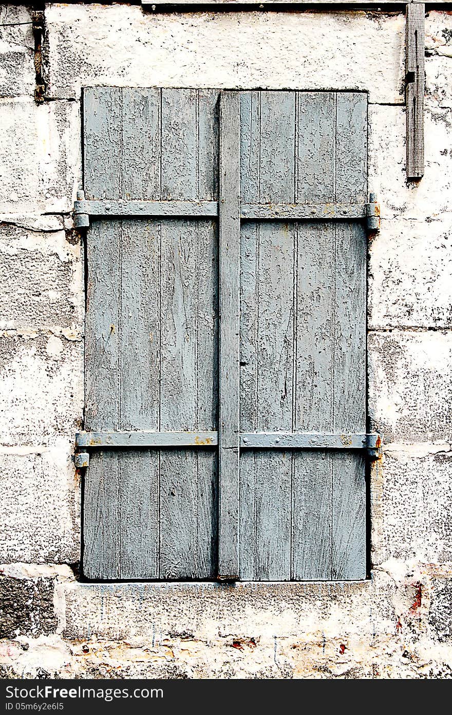 Image of an old window with wooden shutters set in a stone wall. Image of an old window with wooden shutters set in a stone wall