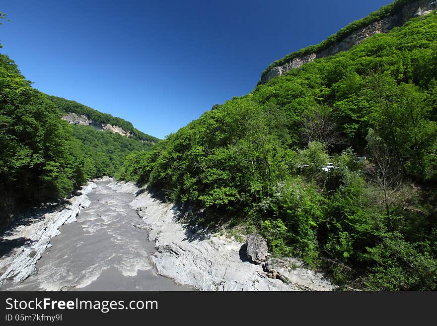 Rapid river narrow mountain path in Russia - Republic of Adygea. Sunny and clear day