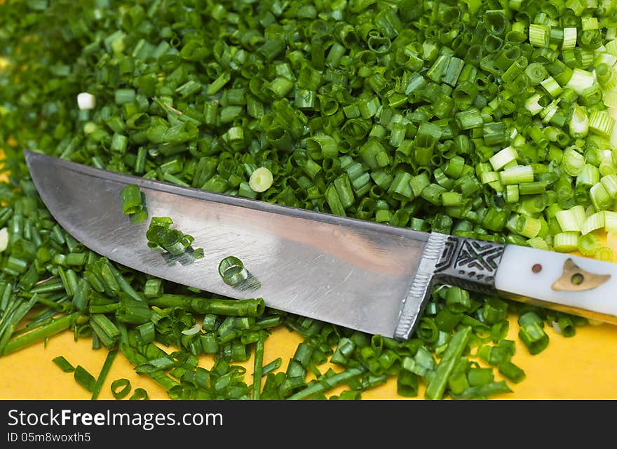 Chopped green onions cutting board with knife on the side. Chopped green onions cutting board with knife on the side