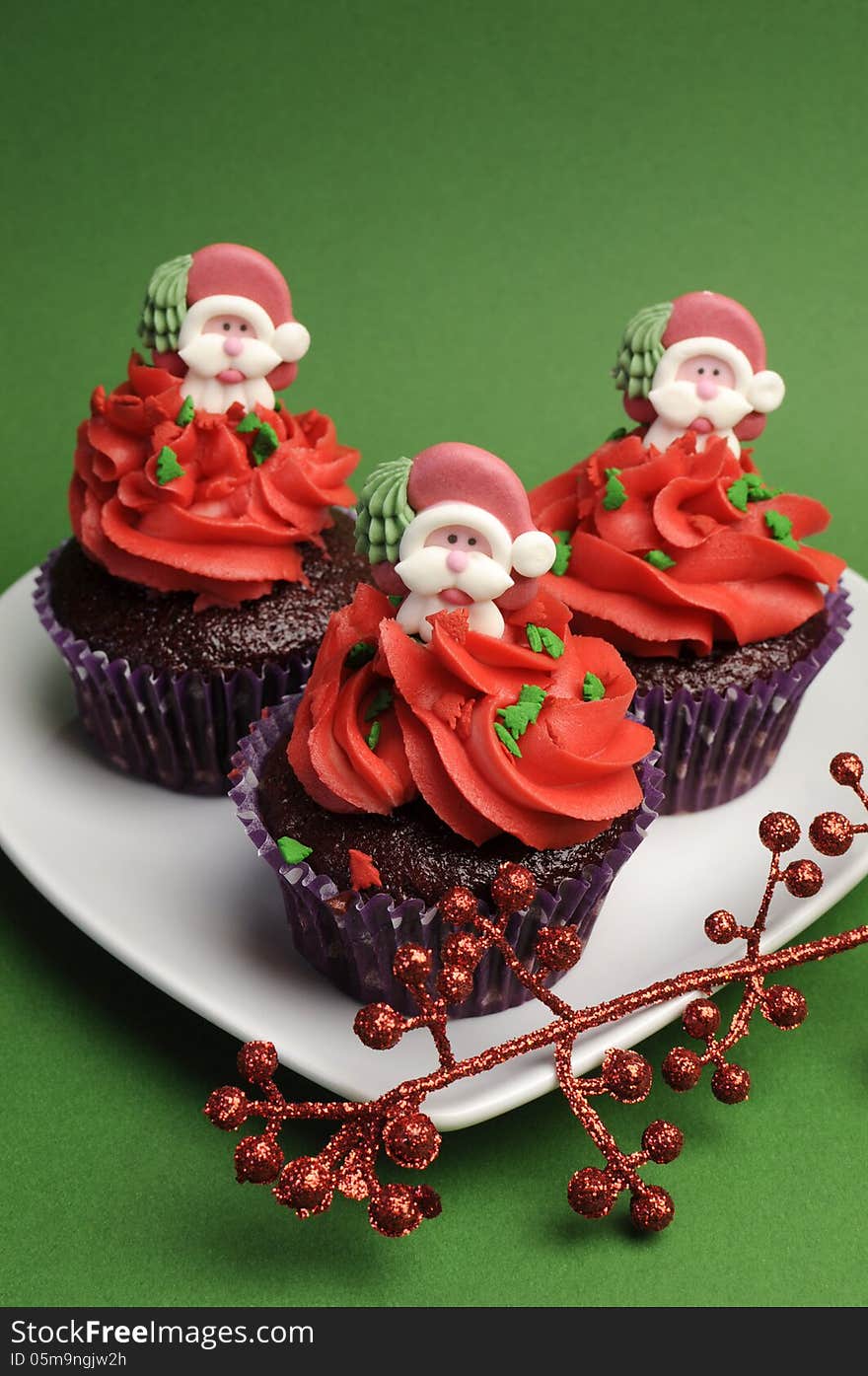 Three Christmas Cupcakes Against A Green Background - Vertical