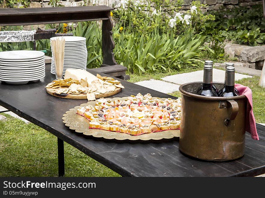 Appetizers on a table with bottles of wine and dishes for guests