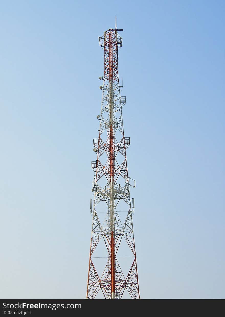 Red tower telecommunication antenna in blue sky