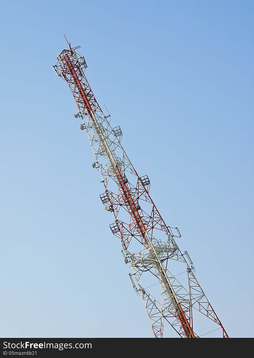 White and red tower telecommunication antenna in blue sky. White and red tower telecommunication antenna in blue sky