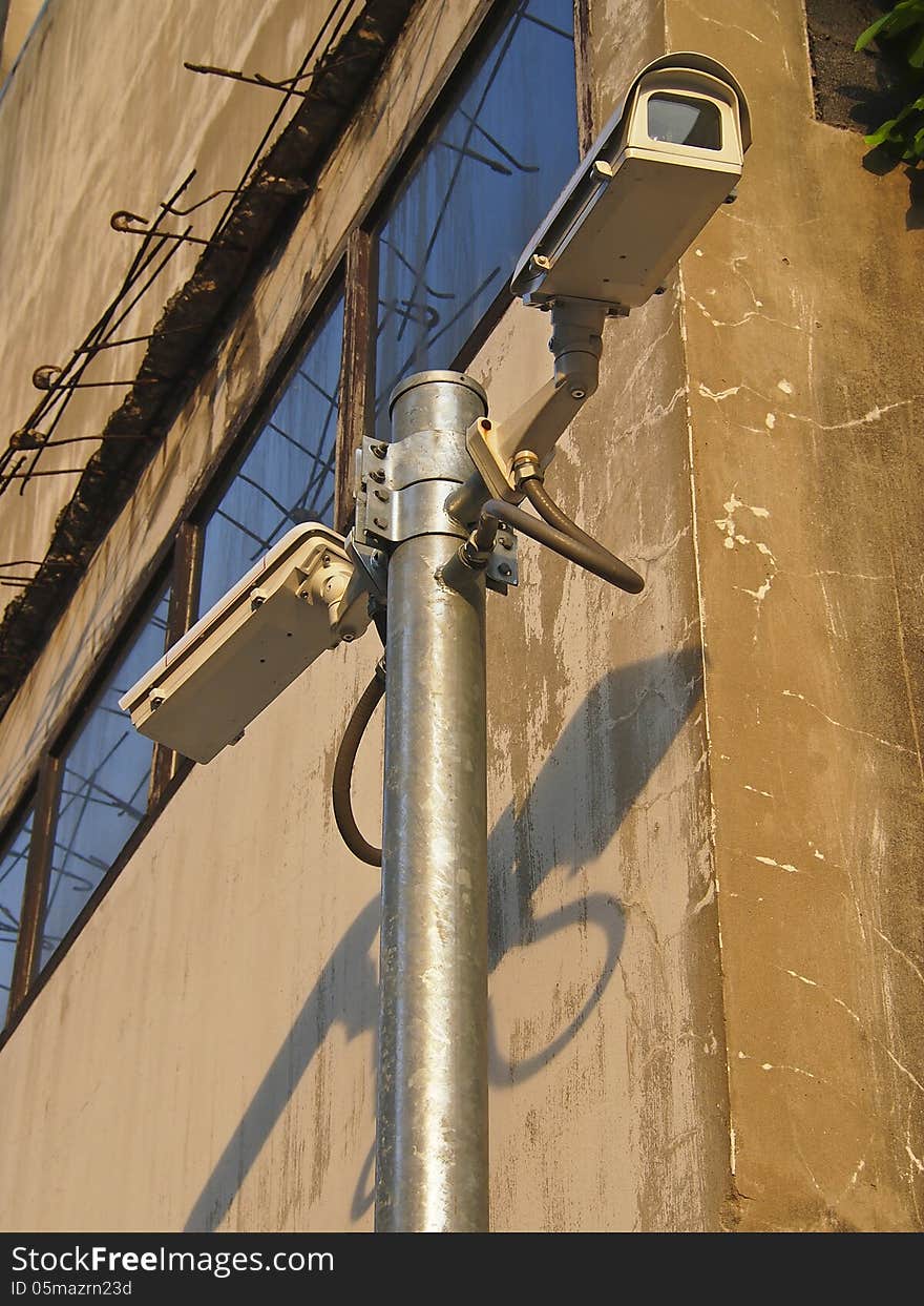 Surveillance cam on pole in building background for security. Surveillance cam on pole in building background for security