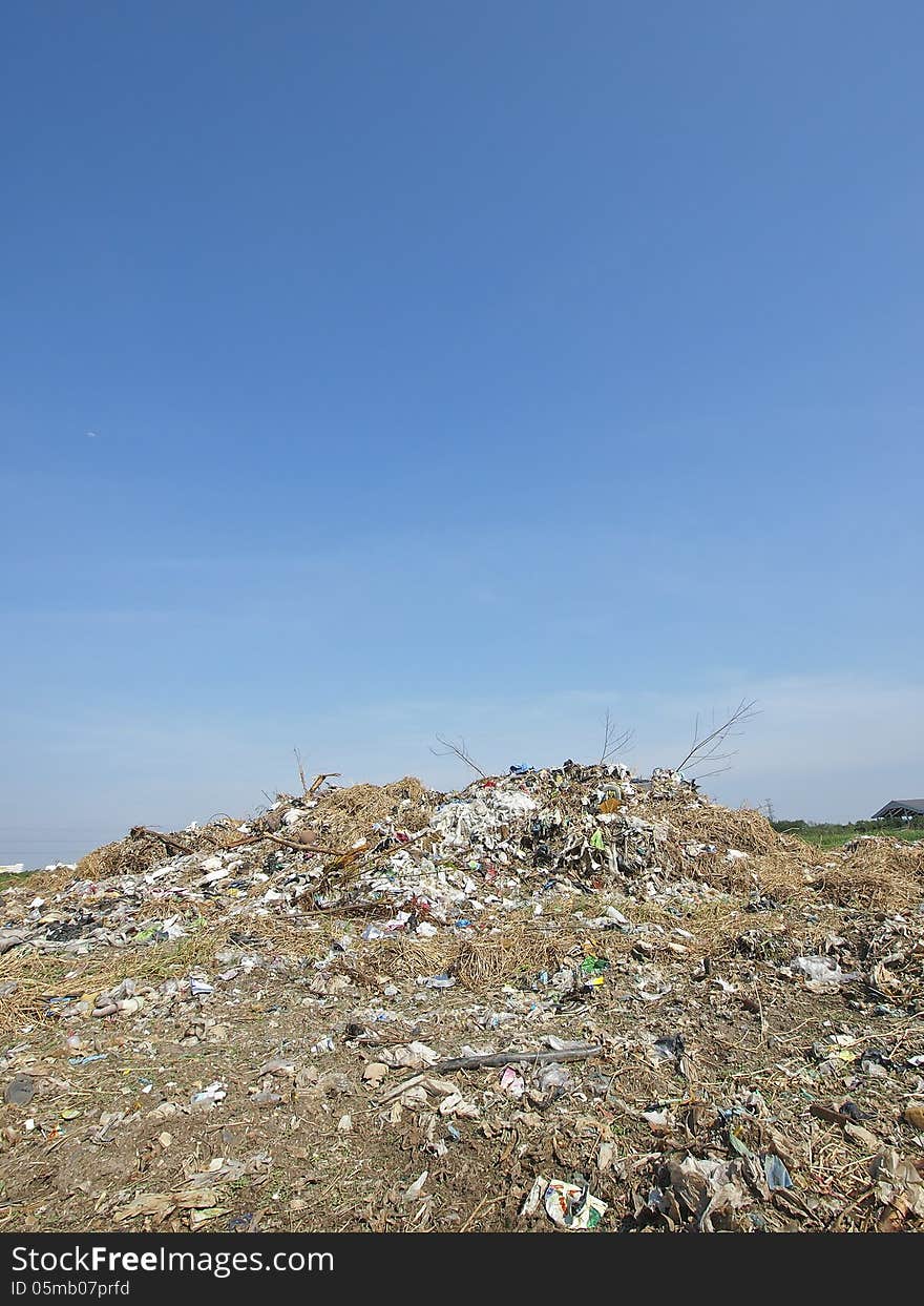 Small pile of garbage in blue sky and sunlight. Small pile of garbage in blue sky and sunlight