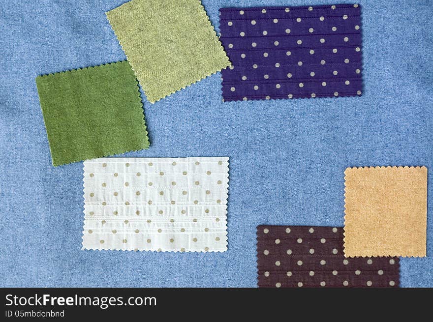 Pieces of colorful fabric on blue fabric