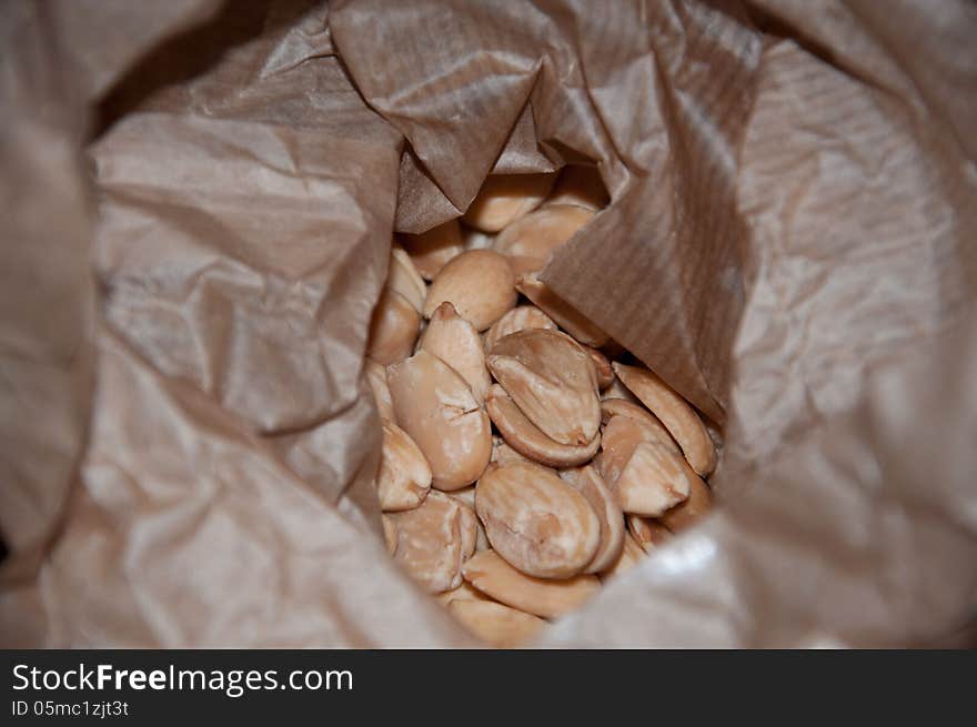 Fresh raw almonds in brown paper bag