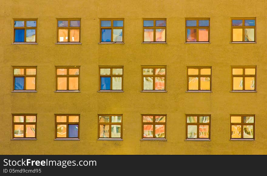 Yellow wall of an office building with blue windows