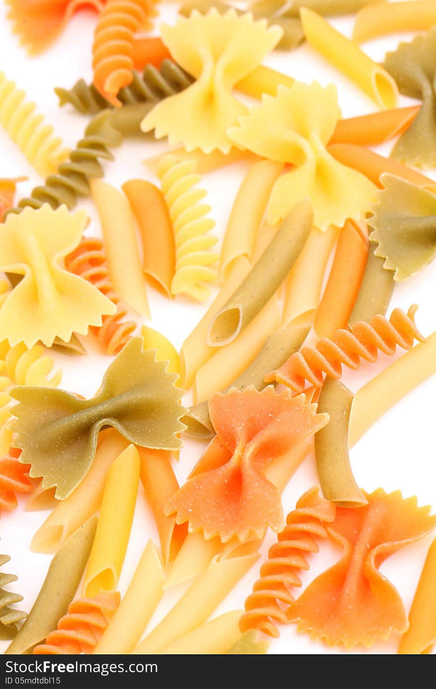 A different pasta in three colors close-up on the white background. A different pasta in three colors close-up on the white background.