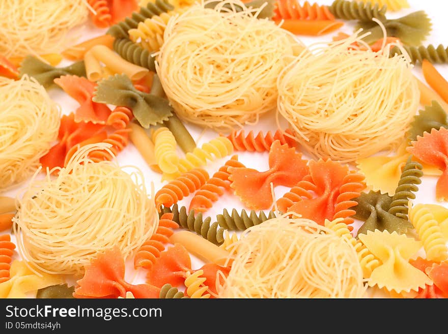 A different pasta in three colors close-up on the white background. A different pasta in three colors close-up on the white background.