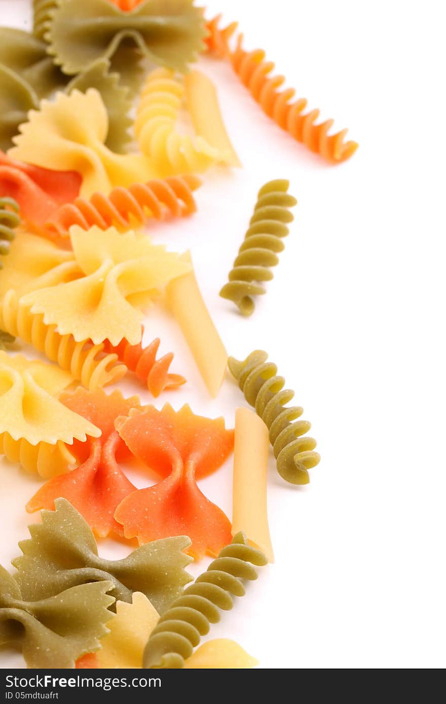 A different pasta in three colors close-up are located right on the white background. A different pasta in three colors close-up are located right on the white background.