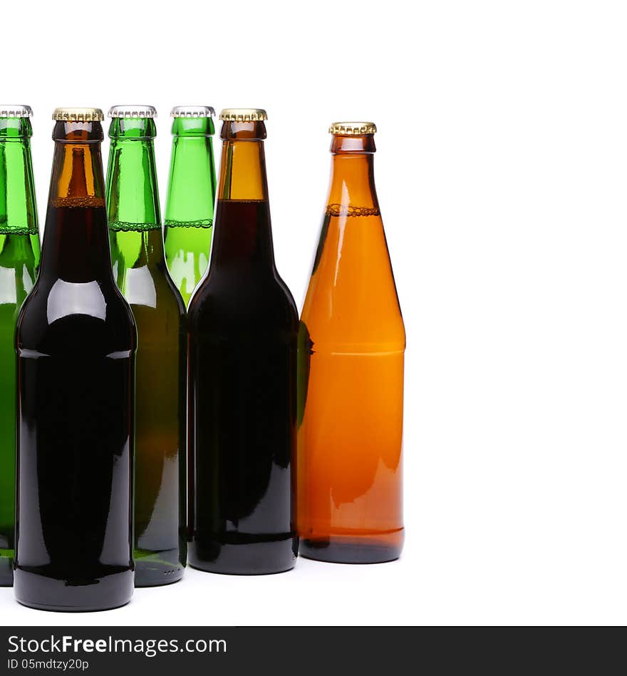 Closed bottles of beer are located left on a white background. Closed bottles of beer are located left on a white background