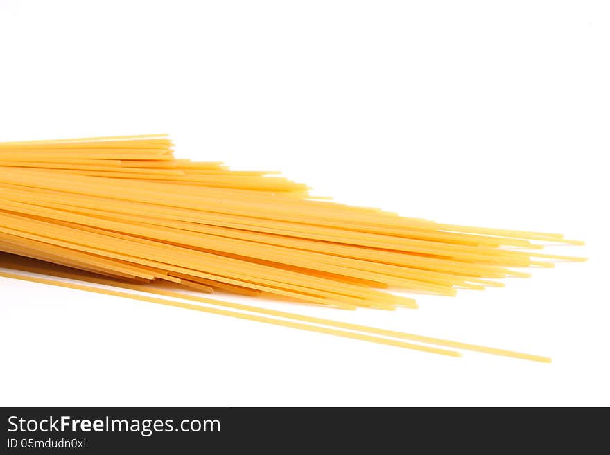 Uncooked spaghetti are located right on a white background. Uncooked spaghetti are located right on a white background