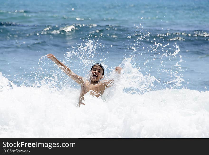 Boy plays with the waves of the sea. Boy plays with the waves of the sea