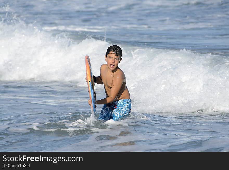 A boy with his tablet to surf on blue waves of the Mediterranean Sea. A boy with his tablet to surf on blue waves of the Mediterranean Sea