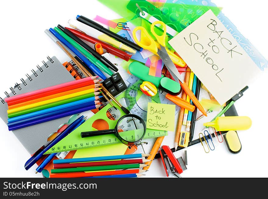 Back to School. Various Stationery Items with Pens, Pencils, Paint Brushes, Felt In Pens, Erasers and Lines on Checked Note Pad isolated on white background