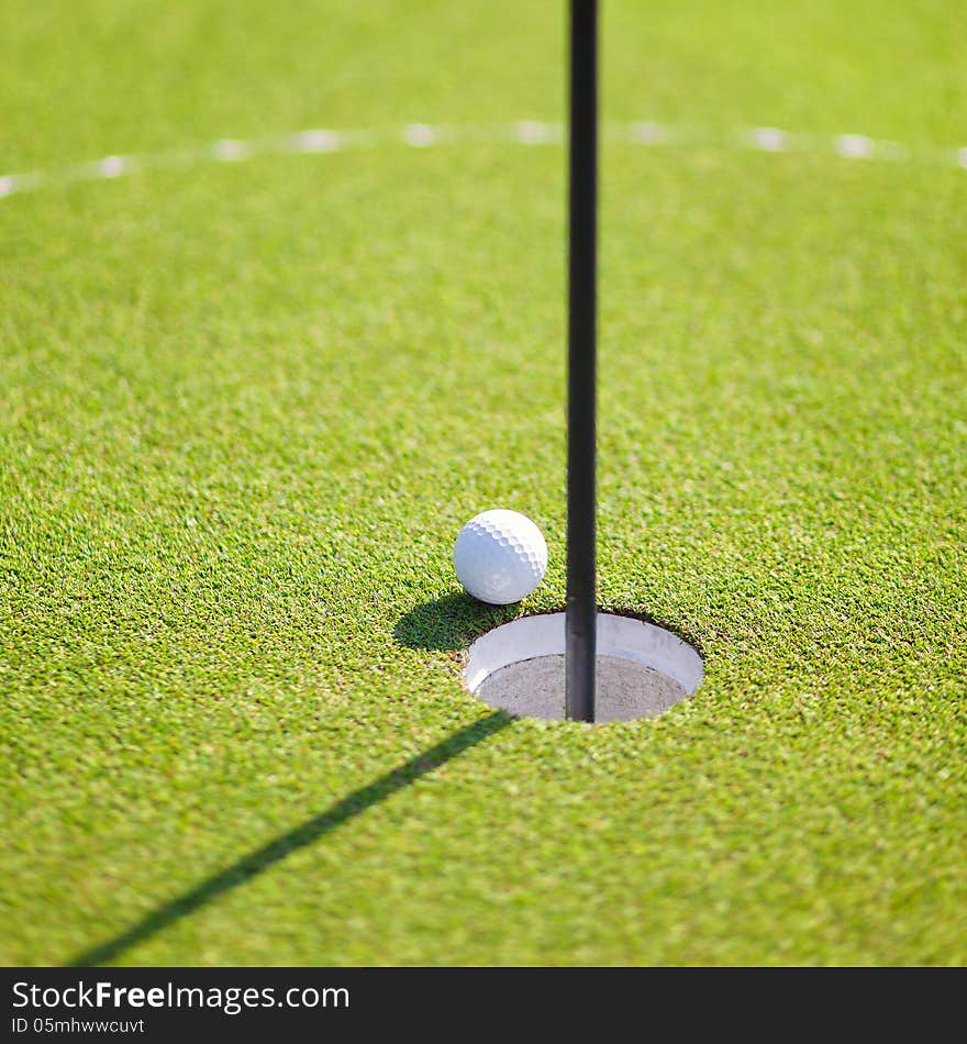 Golf ball on lip of cup