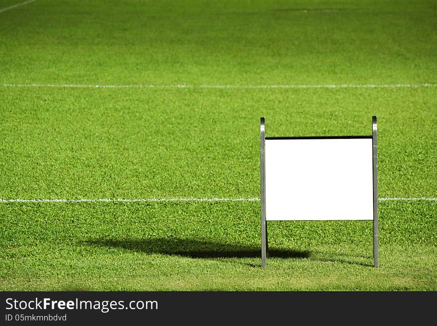 Grass field with blank notice board, really for text or photo insert.