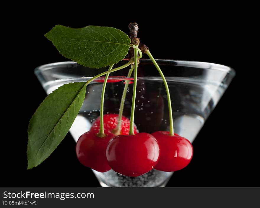 Cherries in a martini glass on black. Cherries in a martini glass on black.