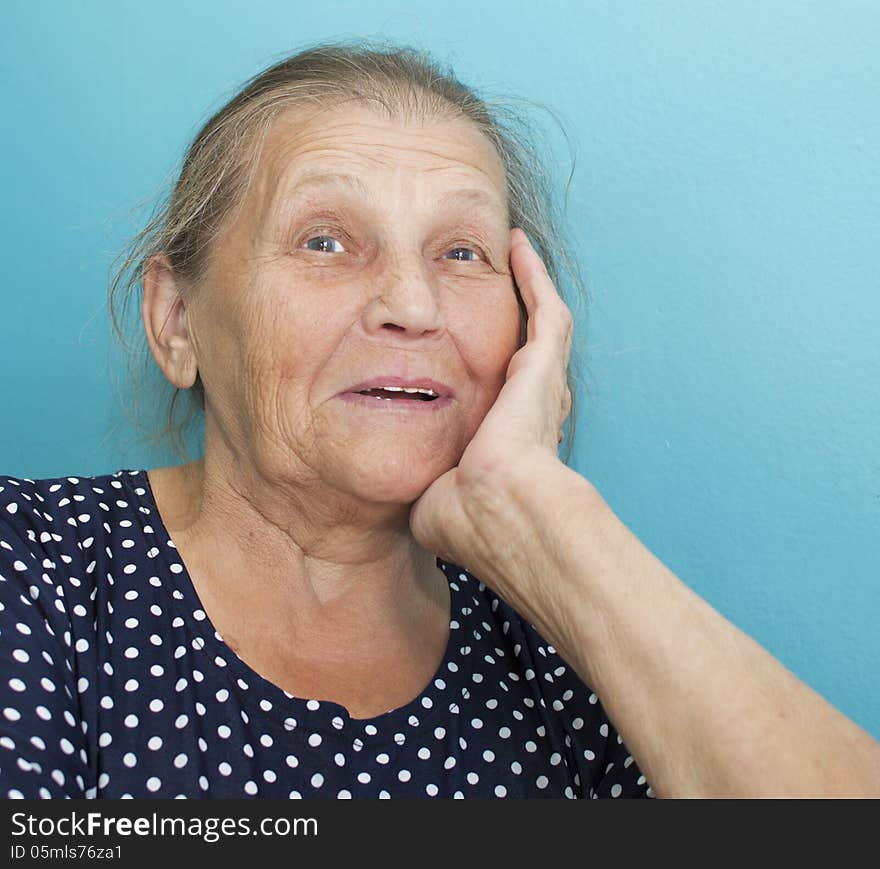 The happy elderly woman supports the head a hand and laughs. The happy elderly woman supports the head a hand and laughs.