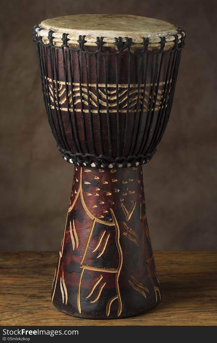 Vertical photo of african hand drum with soft diffused light brown background