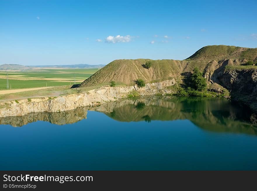 Blue lake with blue sky in reflection