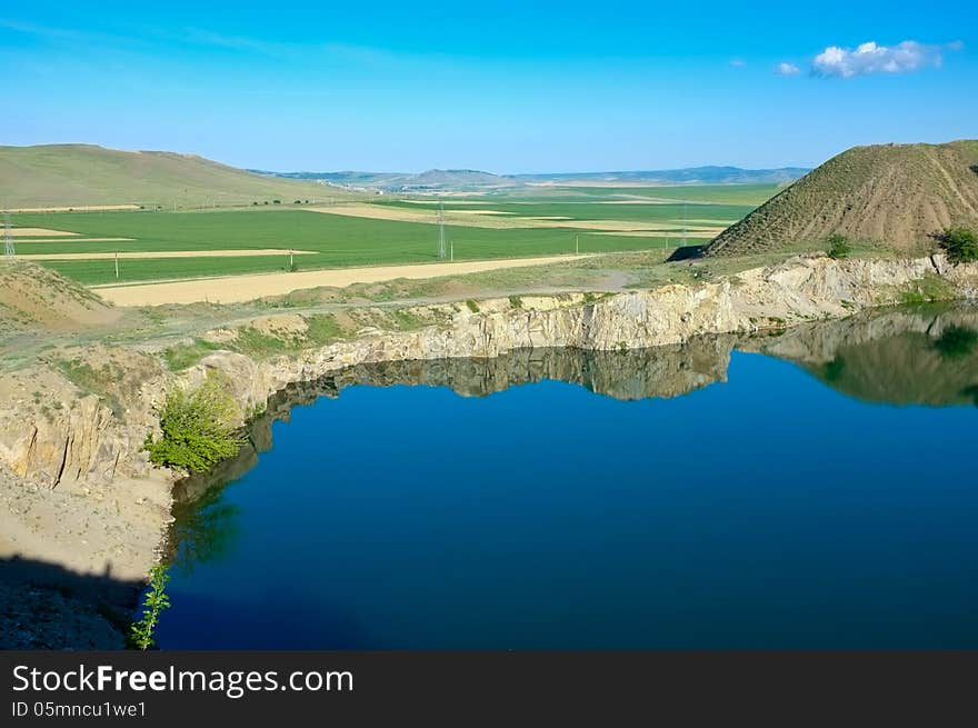 Blue lake with blue sky in reflection