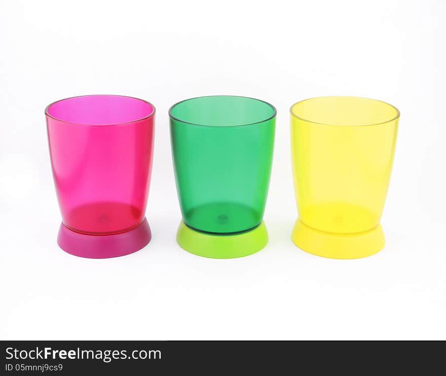 Colorful plastic cups, kitchen utensils isolate on white background