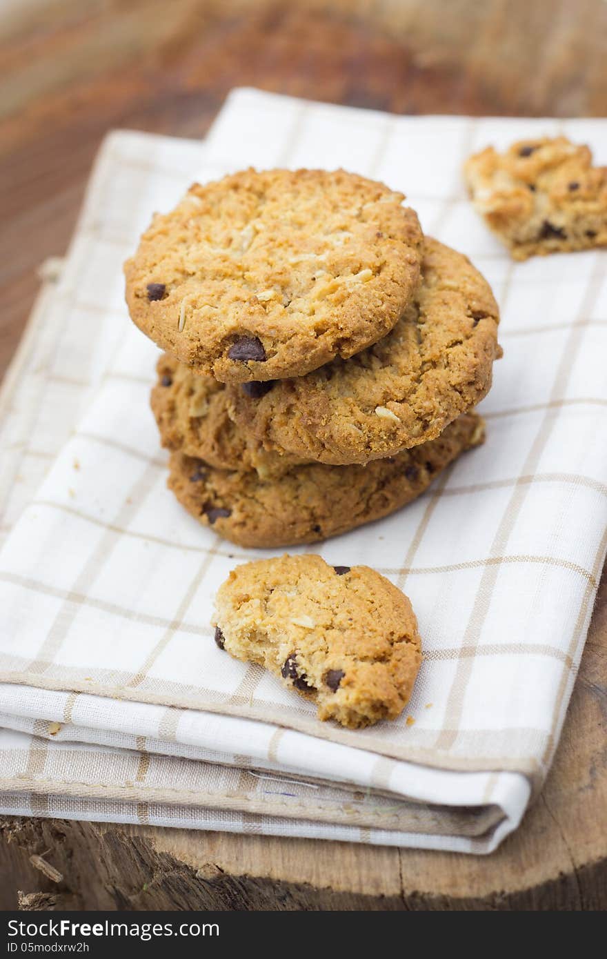 Stacked chocolate chip cookies on white napkin