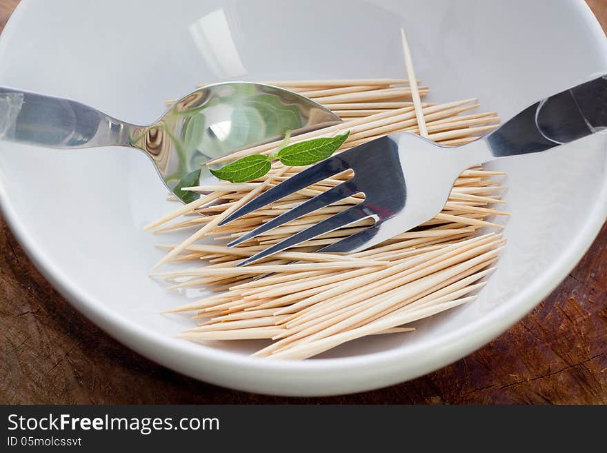 Bamboo skewers in plate on table closeup. Bamboo skewers in plate on table closeup