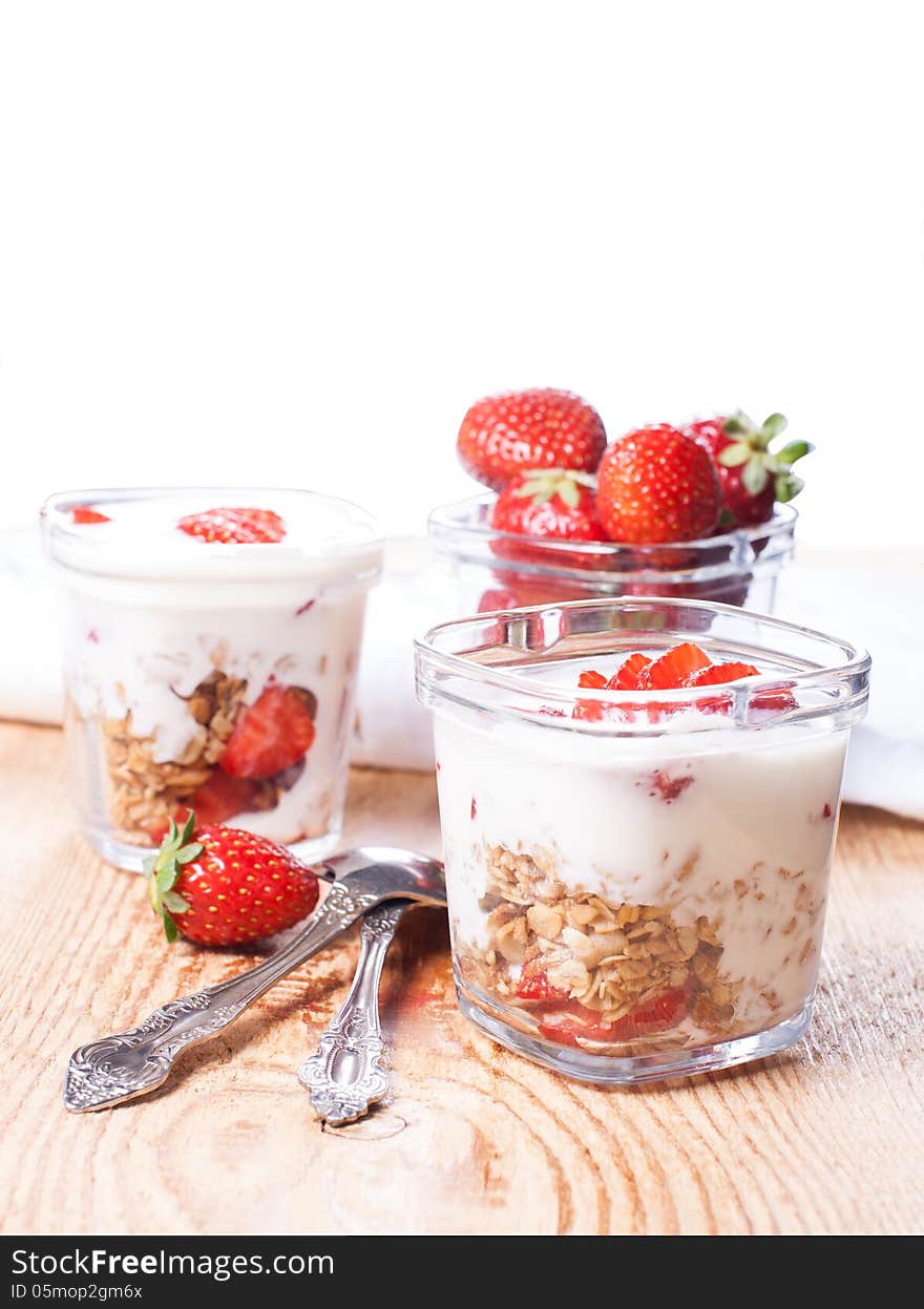 Yougrt, strawberries and granola in glass jars. Yougrt, strawberries and granola in glass jars