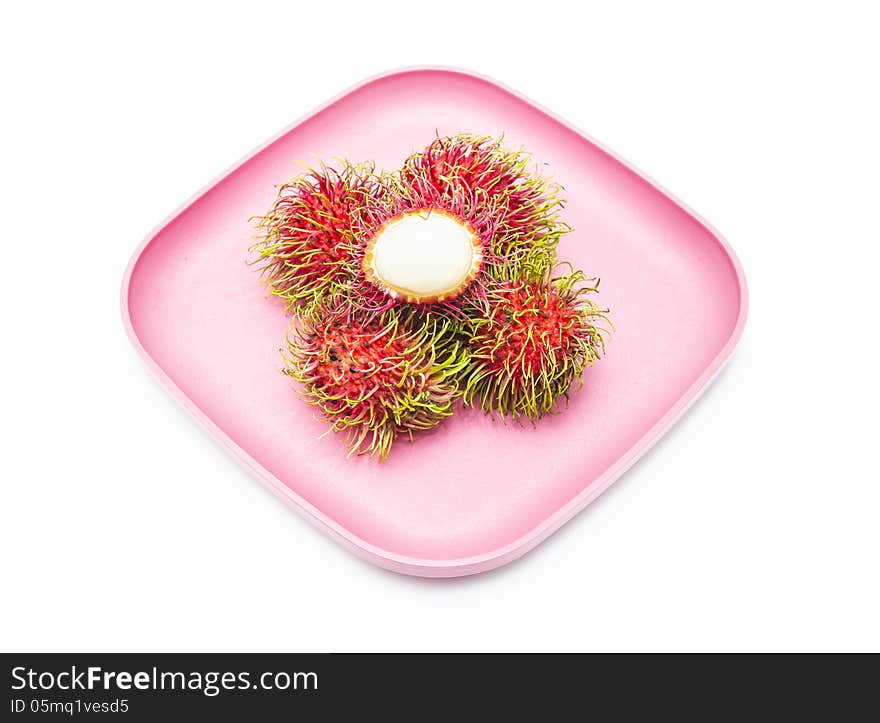 Rambutan in pink dish isolated on white background.