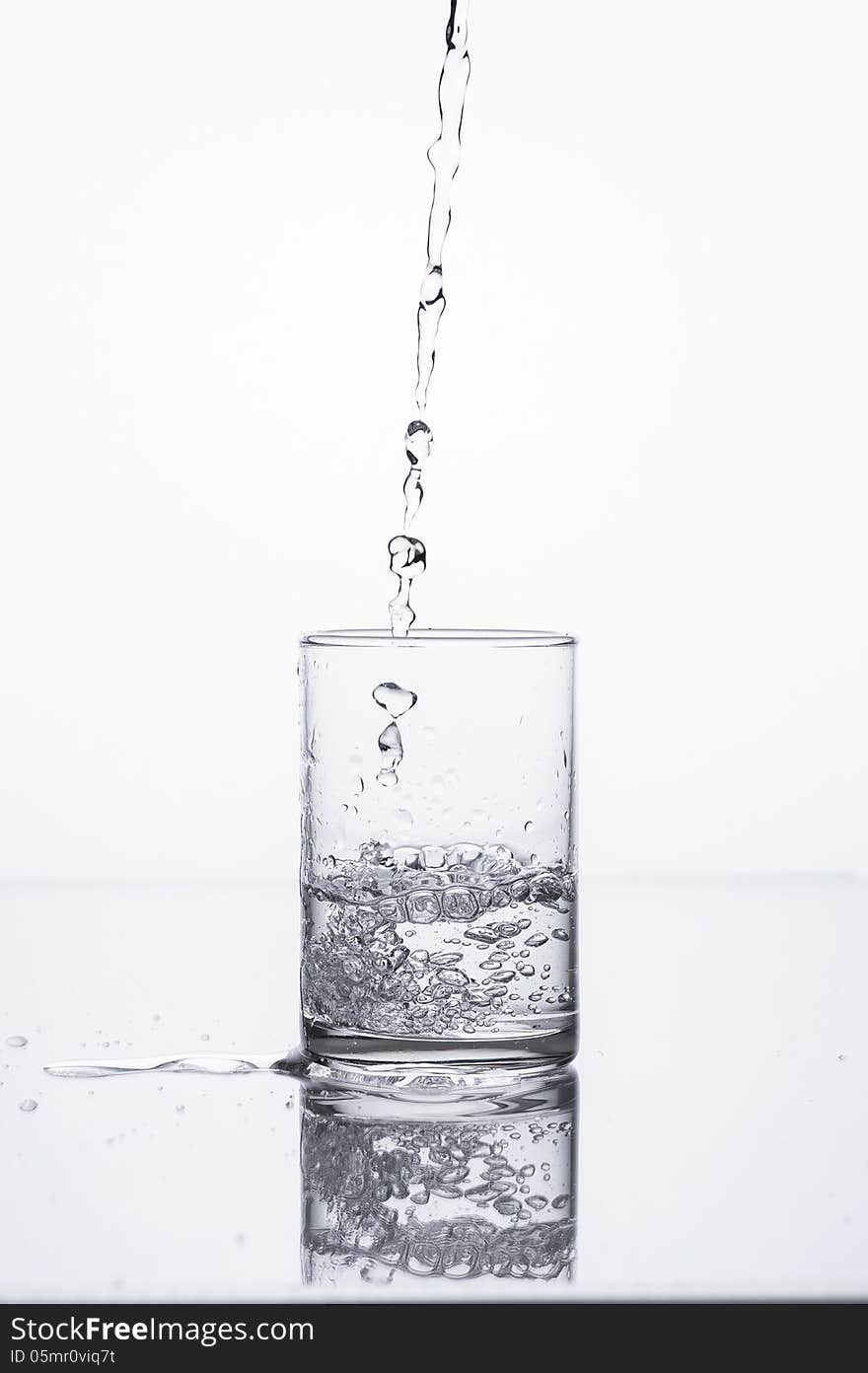 Pouring liquid in to glass on white background